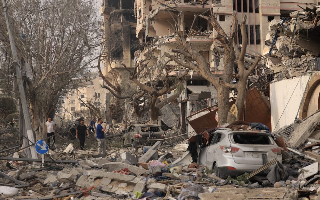 Palestinians inspect the massive destruction from Israeli airstrikes in Gaza City, on October 10, 2023. Israel kept up its deadly bombardment of Hamas-controlled Gaza on October 10 after the Palestinian militant group threatened to execute some of the around 150 hostages it abducted in a weekend assault if air strikes continue without warning. (Photo by MAHMUD HAMS / AFP)