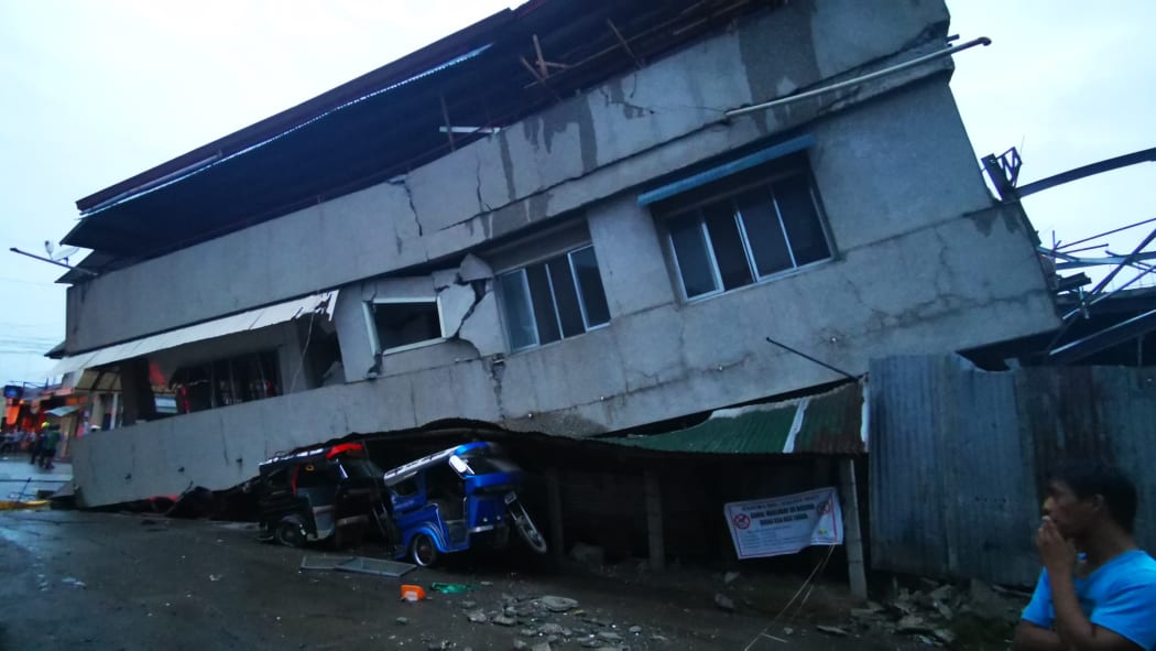A house collapsed onto a vehicle in Davao after the 6.8 earthquake.
