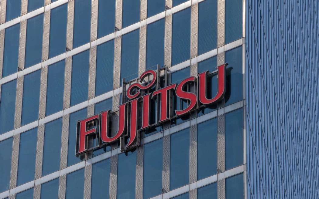 26 March 2021, Bavaria, Munich: The Fujitsu logo hangs on the facade of an office building in Parkstadt Schwabing, in the north of the Bavarian capital. Photo: Peter Kneffel/dpa (Photo by PETER KNEFFEL / DPA / dpa Picture-Alliance via AFP)