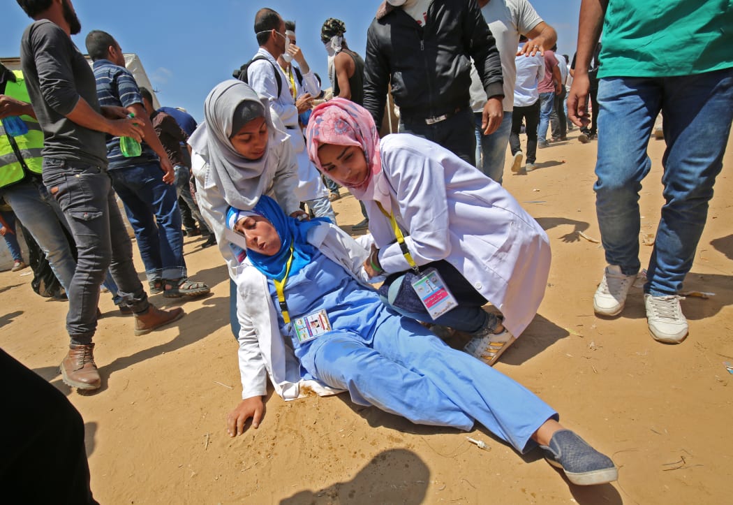 Razan al-Najjar (C-R), a 21-year-old Palestinian paramedic, was killed by Israeli fire on Friday. Here she tends to an injured colleague during clashes near the border in the southern Gaza Strip on May 15, 2018.