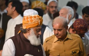 Shahbaz Sharif (R), the younger brother of ousted Pakistani prime minister Nawaz Sharif and head of Pakistan Muslim League-Nawaz (PML-N), arrives with   opposition leader Maulana Fazalur Rehman (L) for a press conference.
