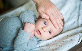 Checking the temperature of 3 month old baby boy.