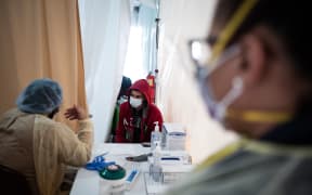 A doctor examines a patient for a Covid-19 test inside a testing tent outside a New York hospital.