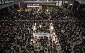 Protesters are seen sitting in the arrival hall in Hong Kong International Airport in Hong Kong.