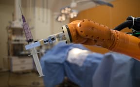 robot in medical concept, robot (artificial intelligence)hold the medical syringe in the operating room  for prepare to surgery the patient for faster recovery time, less cosmetic damage and low costs