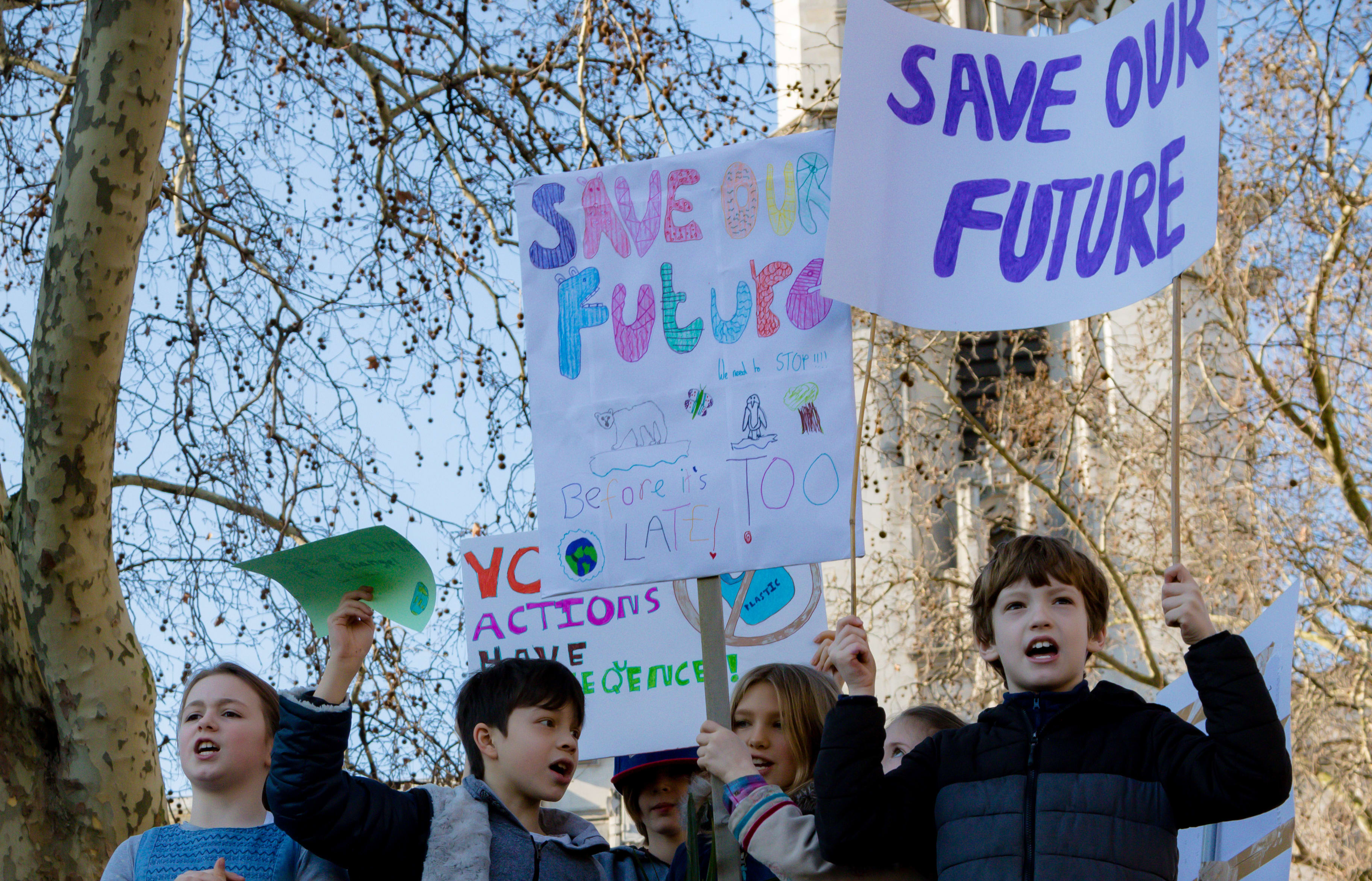Striking school aged children in central London hold climate change holding placards.