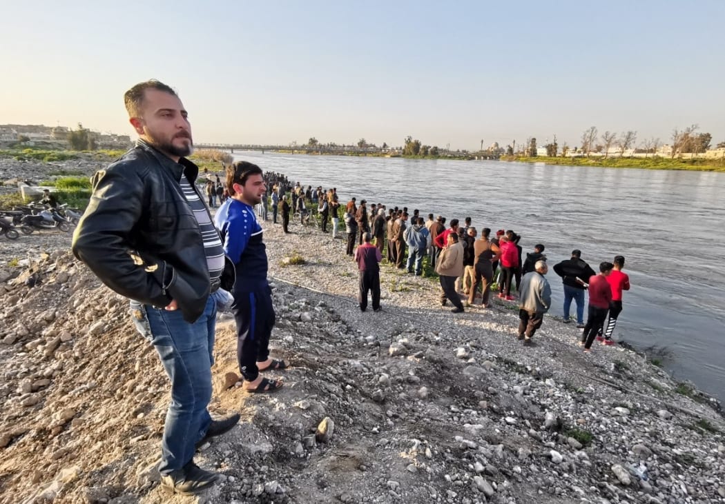MOSUL, IRAQ - MARCH 21: Citizens follow the search and rescue operations around the site after a ferryboat sank in Iraqs Tigris River, leaving at least 55 people dead and more than 100 others injured, in Mosul, Iraq. The ferryboat was reportedly carrying 170 passengers when it sank near Mosul.