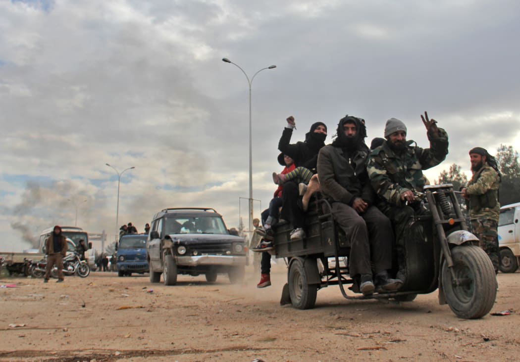 Syrians who were evacuated from rebel-held neighbourhoods in the embattled city of Aleppo celebrate as they arrive in the opposition-controlled Khan al-Aassal region, west of the embattled city, on December 16