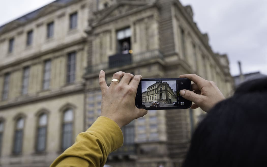 France, Paris, 2025-10-22. Many people come to take photos of the broken display case where the theft took place. On Sunday, 10 October 2025, four criminals stole priceless jewellery while the museum was open. With 10 million visitors, the Louvre is the most visited museum in the world. Photograph by Eric Broncard/Hans Lucas
France, Paris, 2025-10-22. De nombreuses personnes viennent prendre en photo la baie fracturee par ou a eu lieu le vol. Le dimanche 10 octobre 2025, 4 malfaiteurs ont derobe, pendant l’ouverture du musee, des bijoux d’une valeur inestimable. Avec ces 10 millions de visiteurs, le Louvre est le musee le plus visite au monde. Photographie par Eric Broncard/Hans Lucas (Photo by Eric Broncard / Hans Lucas via AFP)