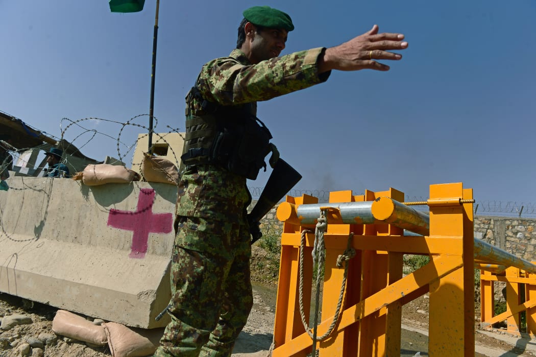 An Afghan National Army soldier outside the military facility where the general was shot and up to 15 soldiers wounded.