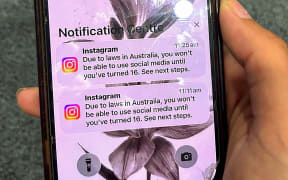 A teenager holds a mobile phone displaying a message from social media platform Instagram after the account was locked for age verification in Sydney on 9 December, 2025.