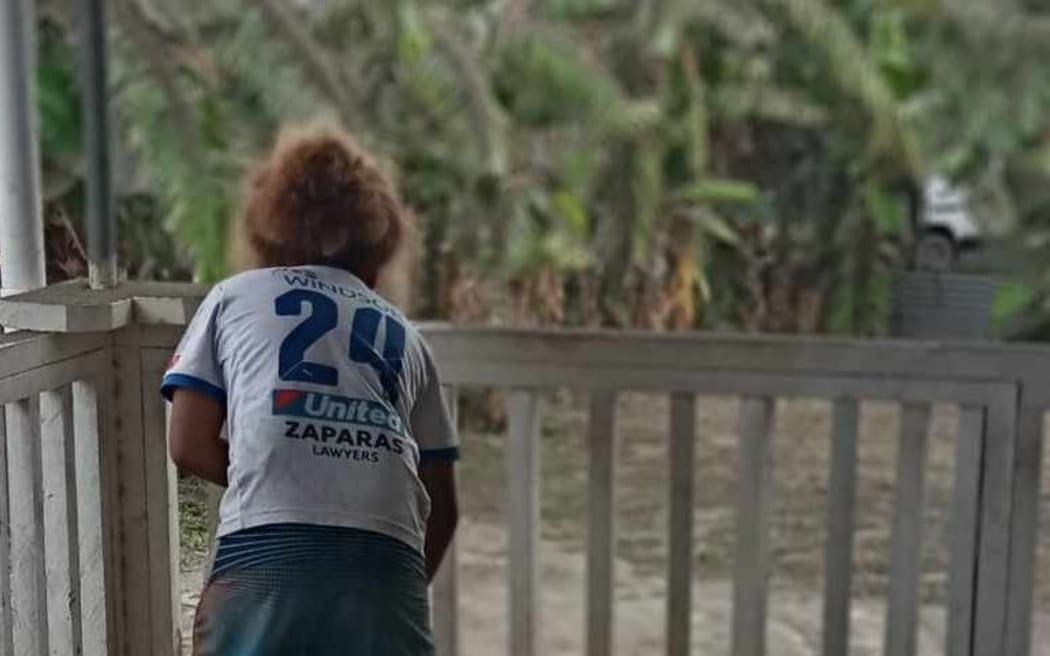 Young Samuela Tora cleans up the verandah at home on 16 January 2022.