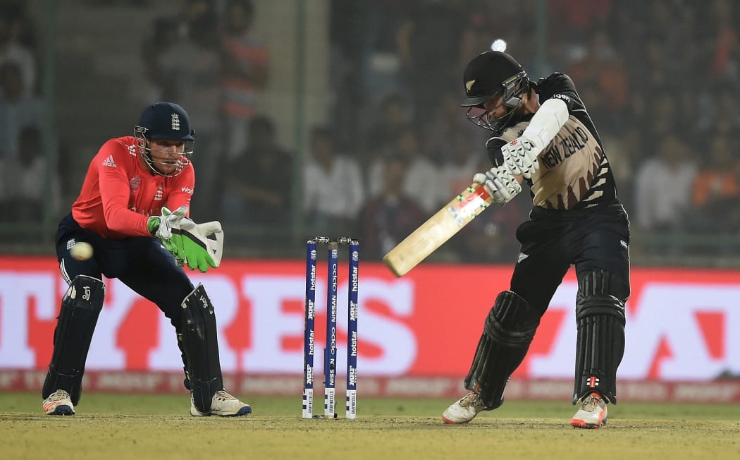 New Zealand's captain Kane Williamson, right, plays a shot as England's wicket keeper Jos Buttler looks on.