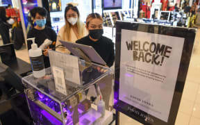 People shop in a department store in Melbourne on October 29, 2021 as the city further lifts Covid restrictions allowing non-essential retail shops to open and travel to the regions of Victoria after the city's sixth lockdown.