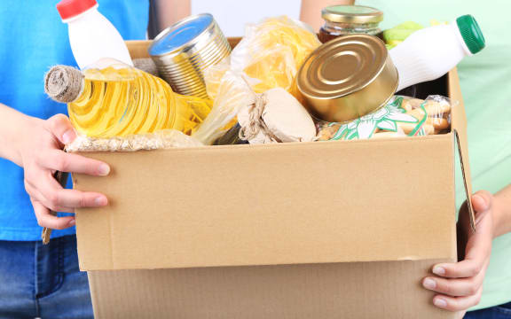 Volunteers with donation box with foodstuffs on grey background - food bank, foodbank
