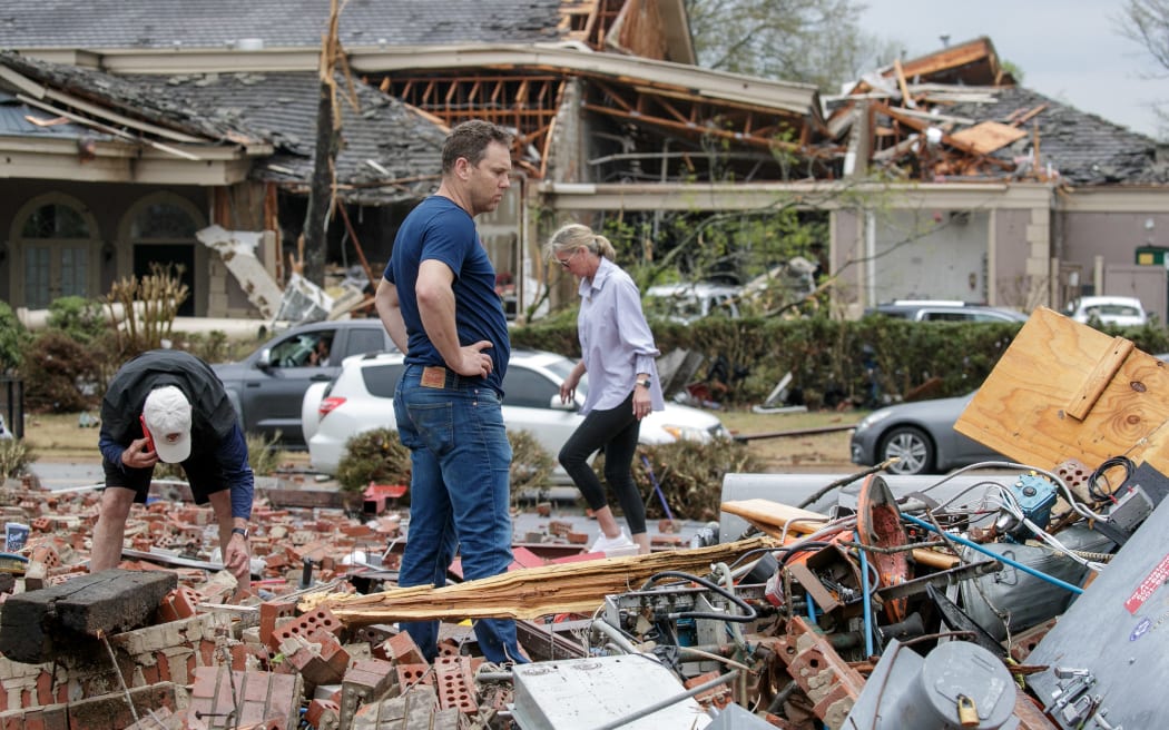 LITTLE ROCK, AR - MARCH 31: Kris French (C) and his family search through rubble for a video recorder they think captured a direct tornado strike to their business, Champs Car Wash, after a tornado damaged hundreds of homes and building on March 31, 2023 in Little Rock, Arkansas. Tornados damaged hundreds of homes and buildings Friday afternoon across a large part of Central Arkansas. Governor Sarah Huckabee Sanders declared a state of emergency after the catastrophic storms that hit on Friday afternoon. According to local reports, the storms killed at least three people.   Benjamin Krain/Getty Images/AFP (Photo by Benjamin Krain / GETTY IMAGES NORTH AMERICA / Getty Images via AFP)