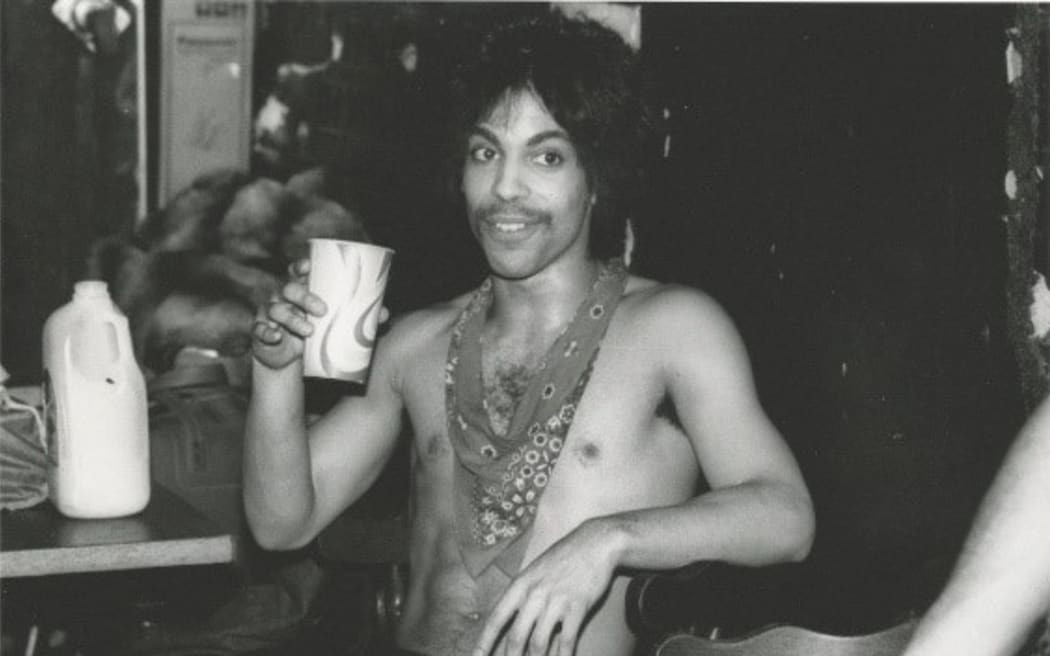 Prince sips some orange juice backstage during the Dirty Mind tour, 1981.