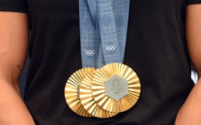New Zealand's most successful Olympic athlete Dame Lisa Carrington displays her three gold medals from the 2024 Paris Olympics.