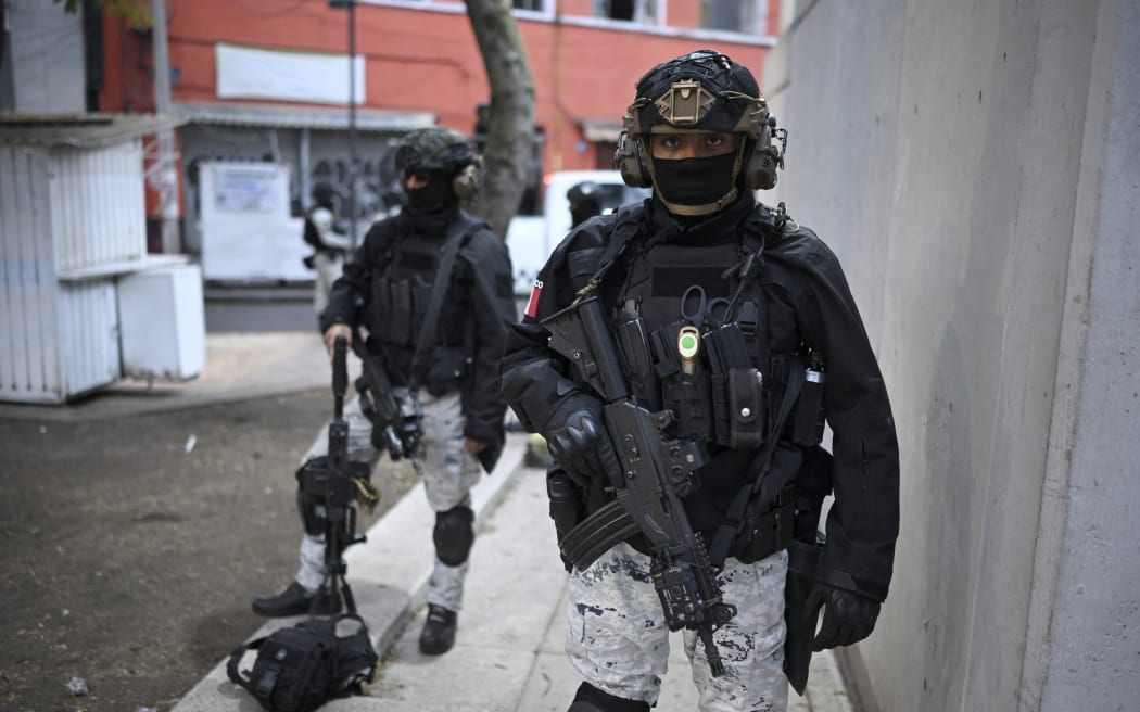 Mexican National Guard special forces stand guard around the Specialized Prosecutor's Office for Organized Crime (FEMDO) headquarters in Mexico City on February 22, 2026. Mexico confirmed on February 22, 2026, that soldiers killed a powerful drug cartel leader who was one of the most wanted men here and in the United States. Nemesio Oseguera, the 59-year-old leader of the violent Jalisco New Generation Cartel, was wounded in a clash with soldiers in the town of Tapalpa and died while being flown to Mexico City, the army said in a statement. (Photo by Alfredo ESTRELLA / AFP)