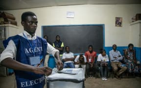 An Independent National Electoral Commission (CENI) agent seals a ballot box in front of observers at the Kitendo voting centre in Lubumbashi's Mapala district on December 30, 2018, following the close of polls in the country's presidential, provincial and national elections.  AFP