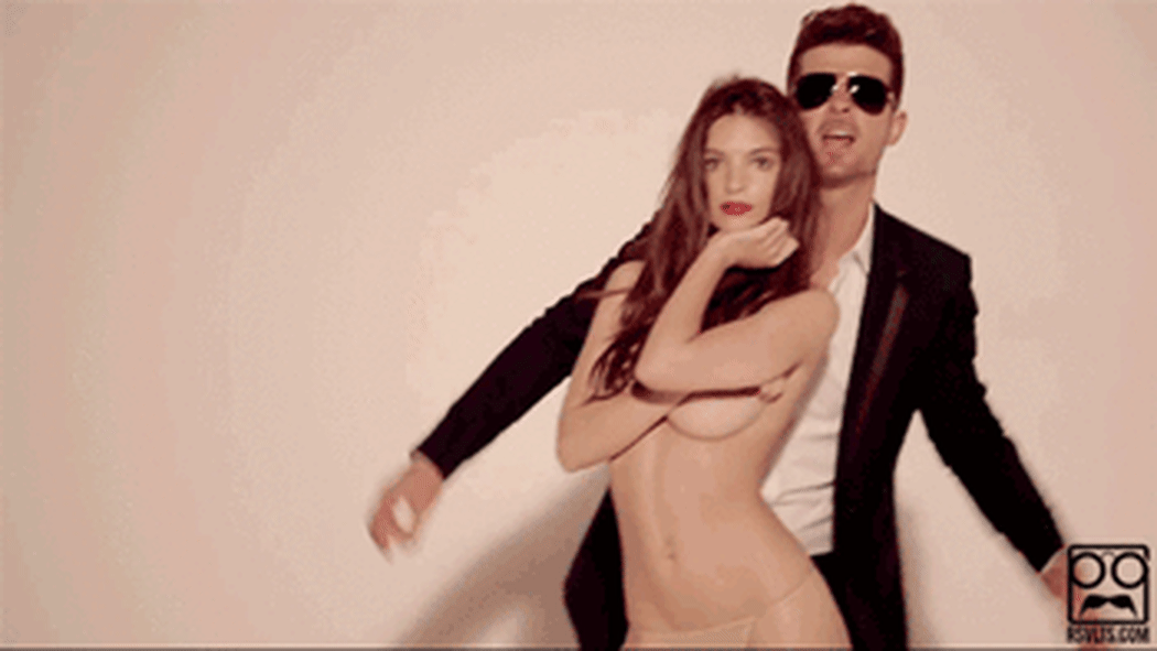 a gif of a mostly naked woman and a fully dressed man from the video of the song Blurred Lines.