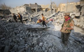 Hammam al_Alil residents inspect the damage caused by air strikes in their town, south of Mosul.