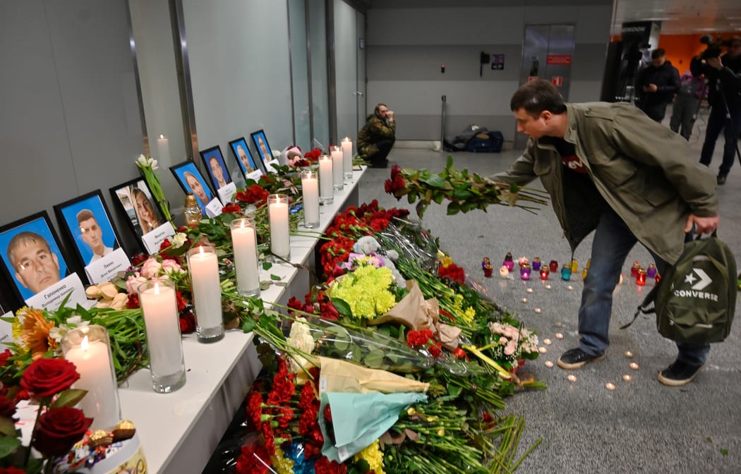 A man places flowers at a memorial for the victims of the Ukraine International Airlines Boeing 737-800 crash in the Iranian capital.