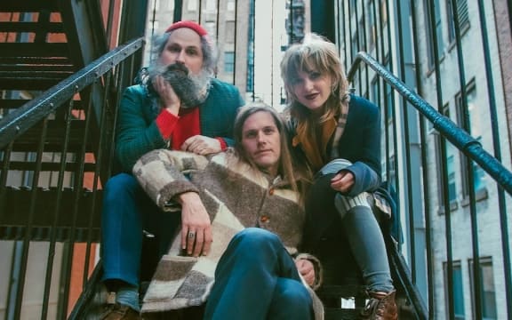 The American trio Bonny Light Horseman ... promo shot sitting on a fire escape staircase