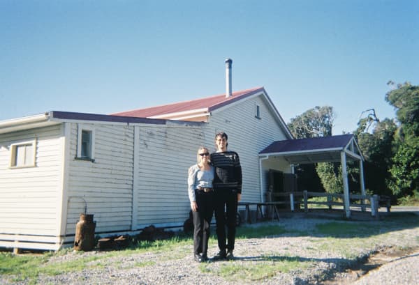 Marlon Williams and Director Ursula Grace Williams stand in front of Haast Hall, the place Te Whare Tīwekaweka was recorded in.
