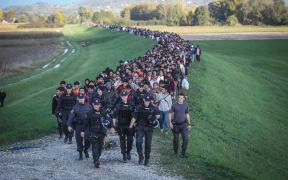 Around 2000 refugees are escorted by the Slovenian police as they walk towards a refugee camp in Brezice, Slovenia.