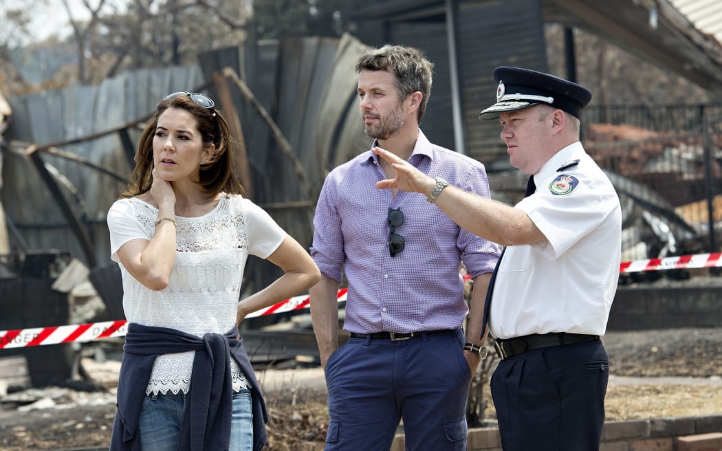 Denmark's Crown Princess Mary (L) and Crown Prince Frederick talk with  Rural Fire Service Commissioner Shane Fitzsimmons as they look at some of 200 homes that were destroyed by a recent bushfire in the Blue Mountains west of Sydney October 27, 2013.