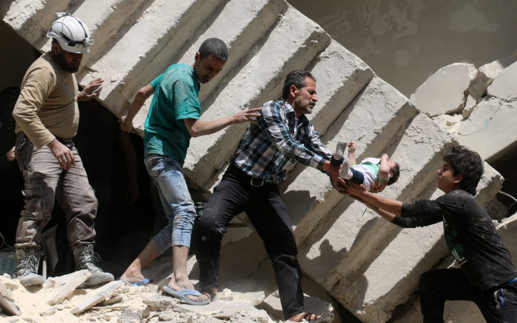 Syrian civil defence volunteers and rescuers remove a baby from under the rubble of a destroyed building following a reported air strike on the rebel-held neighbourhood of al-Kalasa in the northern Syrian city of Aleppo, on April 28, 2016.