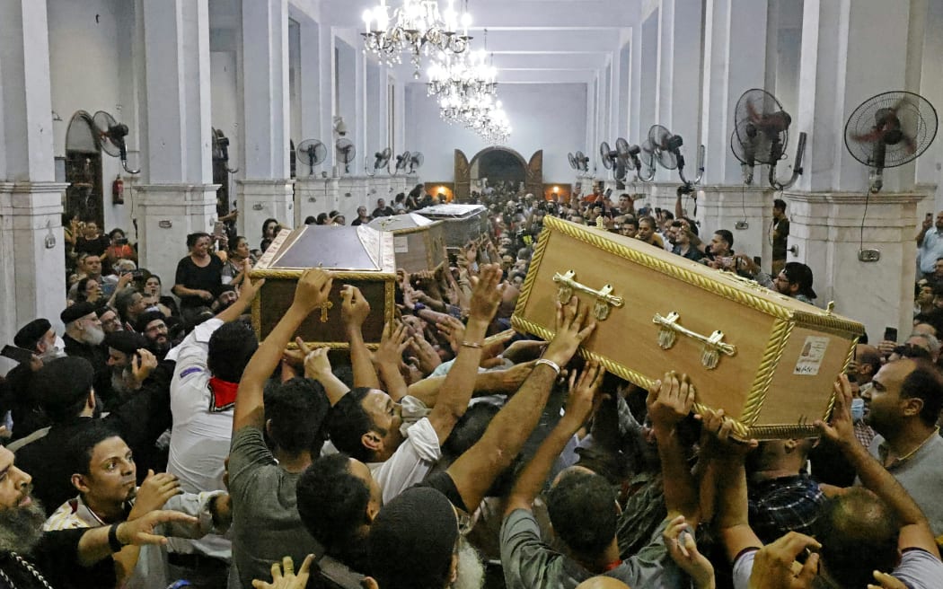 Egyptian mourners carry the coffins of the victims killed in Cairo Coptic Abu Sifin church fire, during a funeral at the church of the Blessed Virgin Mary in Giza on 14 August 2022.