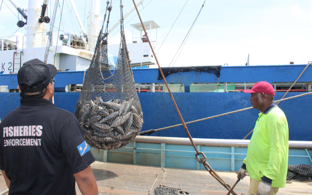 A Marshall Islands Fisheries Enforcement Officer observes the transshipment of tuna from the purse seiner vessel Mathawmarfach to the carrier vessel Cherry Star during a transshipment operation in Majuro Atoll in 2024.