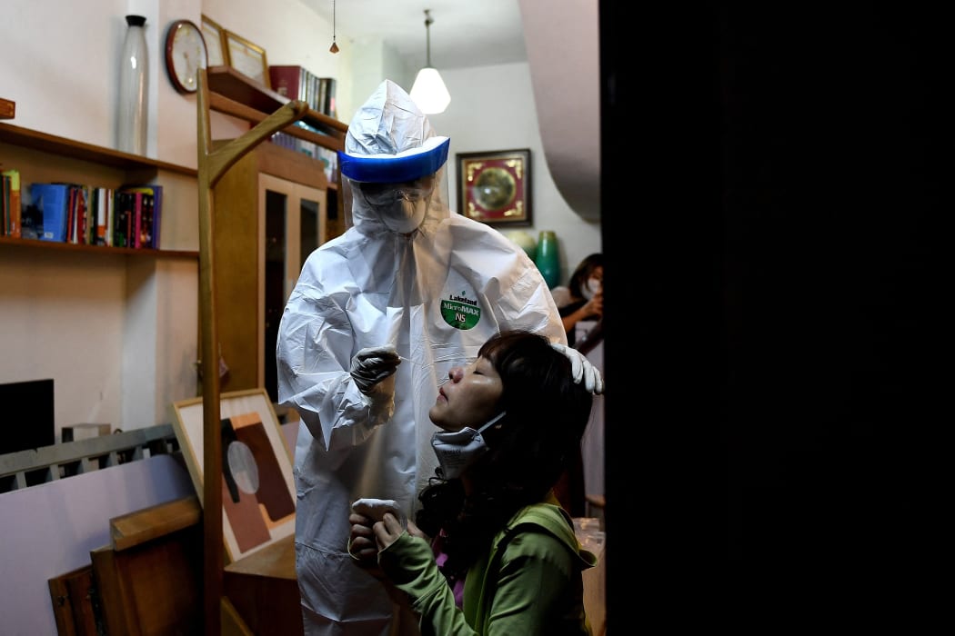 A health worker tests a woman for Covid-19 in her house in Hanoi, Vietnam's capital city.