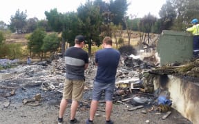 Simon Grace at the remains of his home with his brother.