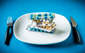 Capsules an pills in a plate. 
France (Photo by VOISIN / Phanie / Phanie via AFP)