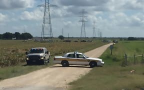 a police vehicle blocking a road where a hot air balloon crashed near Lockhart, Texas, July 30, 2016. Sixteen people are feared to have died