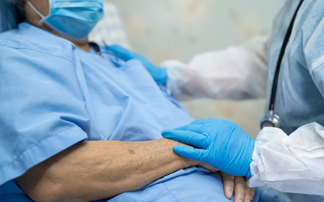 Doctor using stethoscope to checking Asian senior or elderly old lady woman patient wearing a face mask in hospital for protect infection Covid-19 Coronavirus.