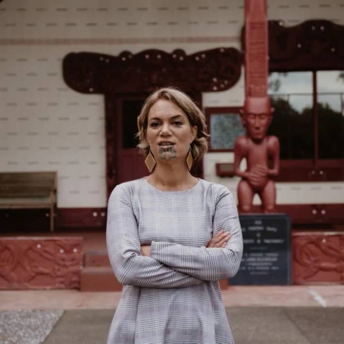 Heeni Hotorene stands with her arms crossed on the forecourt of Te Whare Rūnanga at the historic Waitangi Treaty grounds.