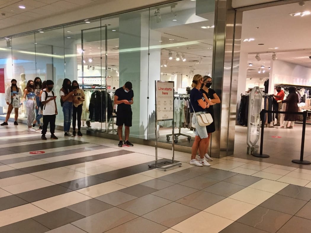 People wait to enter a store in a shopping mall as stores limit the number of customers allowed inside during the novel coronavirus (COVID-19) pandemic in Toronto, Ontario, Canada on July 03, 2021. Ontario is now in the second stage of the 3 stage reopening plan.