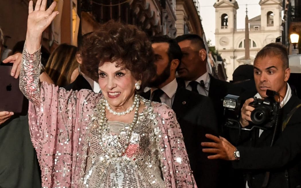 (FILES) In this file photo taken on July 04, 2017, Italian actress Gina Lollobrigida waves as she poses for photographers in Via Condotti to celebrates her 90th birthday, on the red carpet in front of Piazza di Spagna, in central Rome. - Gina Lollobrigida, one of the last icons of the Golden Age of Hollywood, has died aged 95, Culture minister Gennaro Sangiuliano said on Twitter on January 16, 2023. (Photo by ANDREAS SOLARO / AFP)