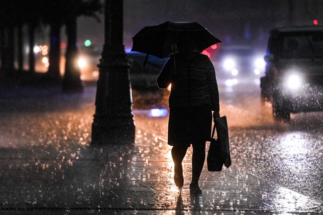 A man with umbrella walks along a street during a heavy rain, in downtown Moscow, Russia.