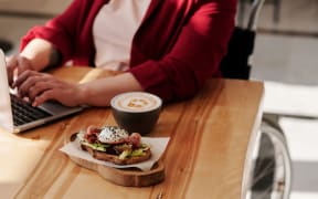 woman in wheelchair with coffee and food