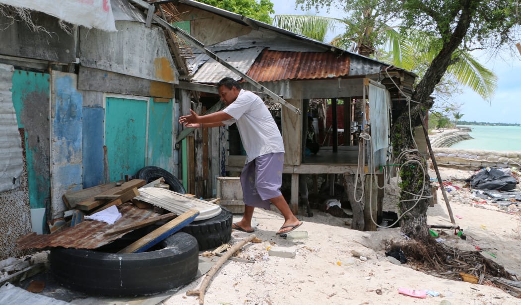 Maerere Eria shows how the water surges through his house during king tides