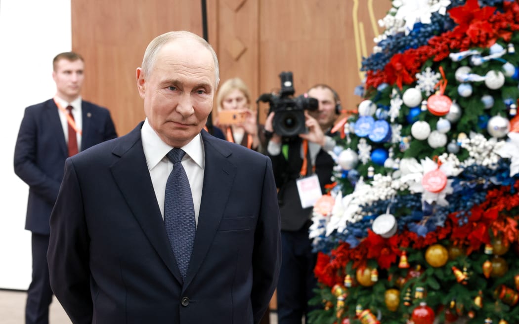 In this pool photograph distributed by the Russian state agency Sputnik, Russia's President Vladimir Putin meets with volunteers during a volunteer organisations forum in Moscow on December 3, 2025. (Photo by Alexander SHCHERBAK / POOL / AFP)
