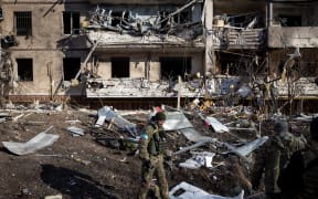 A Ukrainian soldier inspects the rubble of a destroyed apartment building in Kyiv on 15 March 2022.