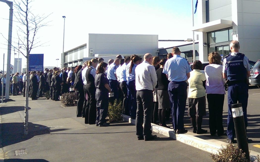 Police staff observe two minutes silence outside Christchurch Central Police Station.