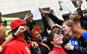 Union organizer Christian Smalls celebrates with Amazon workers following their win.