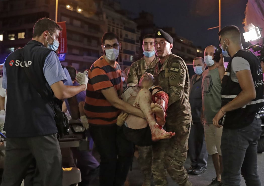 Lebanese army soldiers carry away an injured man at a hospital in the aftermath of an explosion at the port of Lebanon's capital Beirut on August 4, 2020.